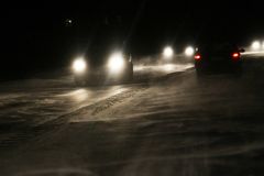 Autot ajavat pimeässä liukkaalla tiellä.