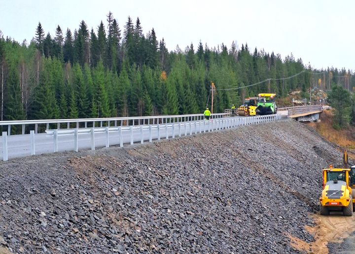 Rakennustyömaa tietyömaalla valtatien reunalla, metsää taustalla.