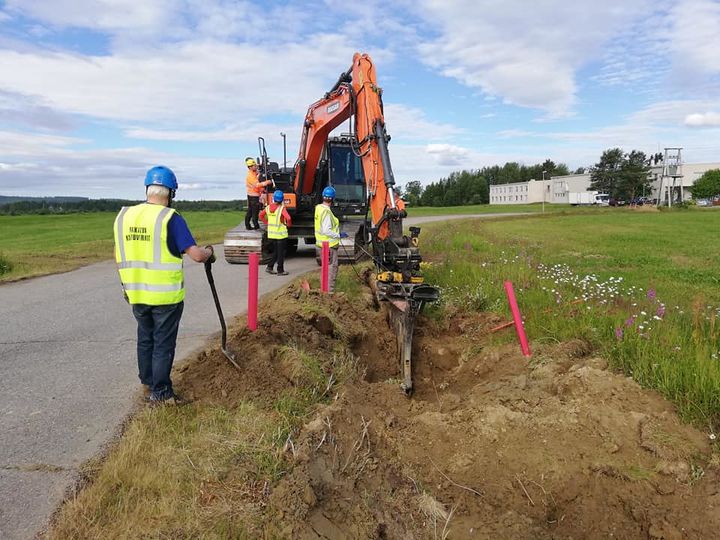 Ihmisiä kaivamassa ojaa laajakaistakaapelilla.