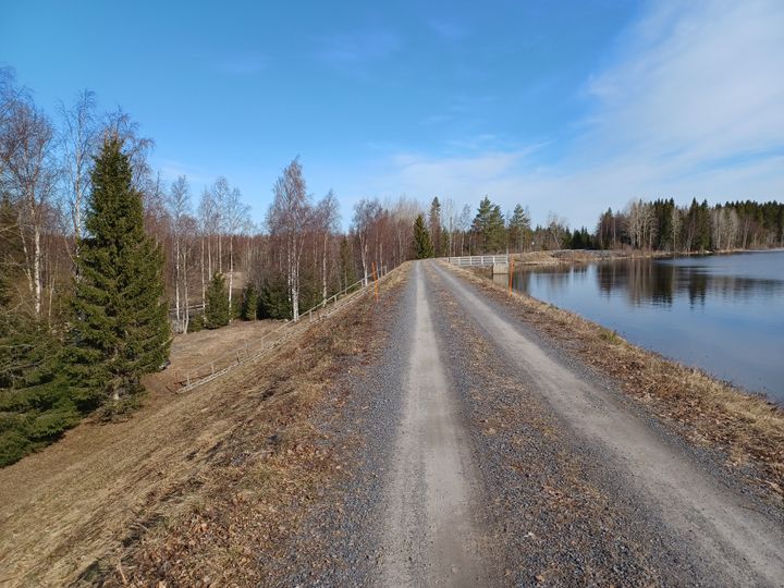 Penkereen päällä kulkeva soratie ja tekojärvi.