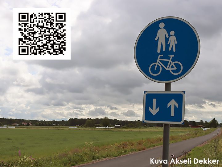 Etualalla kevyen liikenteen väylän liikennemerkki, taustalla virheiden niittyjen välissä kulkeva kevyen liikenteen väylä.