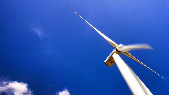 Yksittäinen tuulivoimala kurkottaa taivaalle.