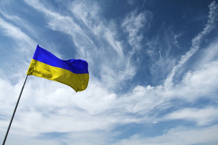 Ukrainan lippu liehuu tangossa sinistä taivasta vasten.