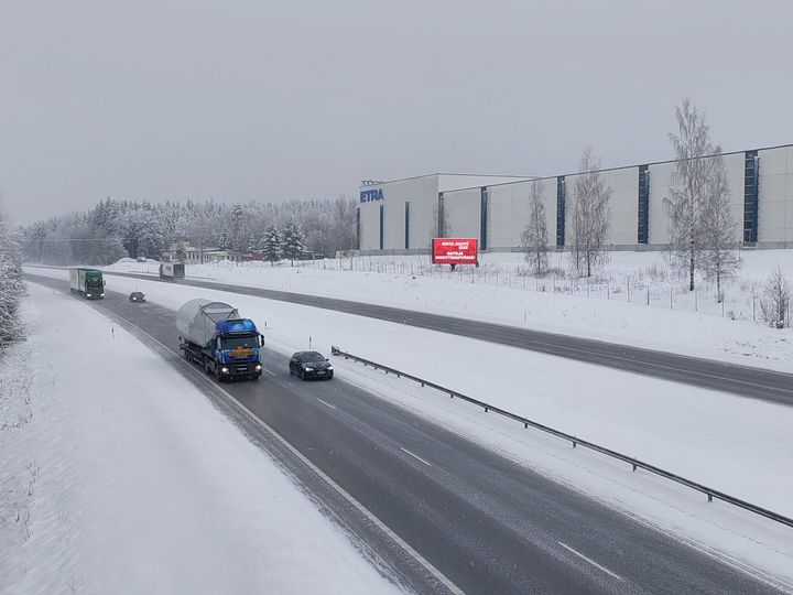 Kuvassa rekka lumisella maantiellä.