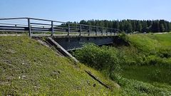Keihäsjoen silta kesäpäivänä, ympärillä vihreää maisemaa.