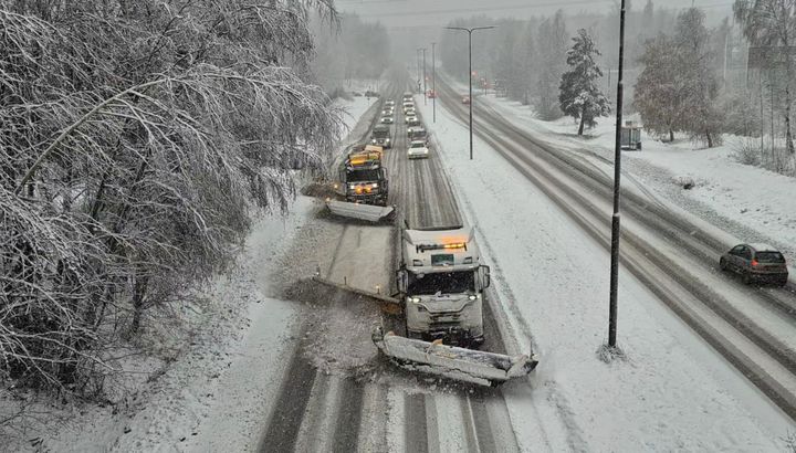 På bilden syns en snötäckt landsväg och snöplogar.