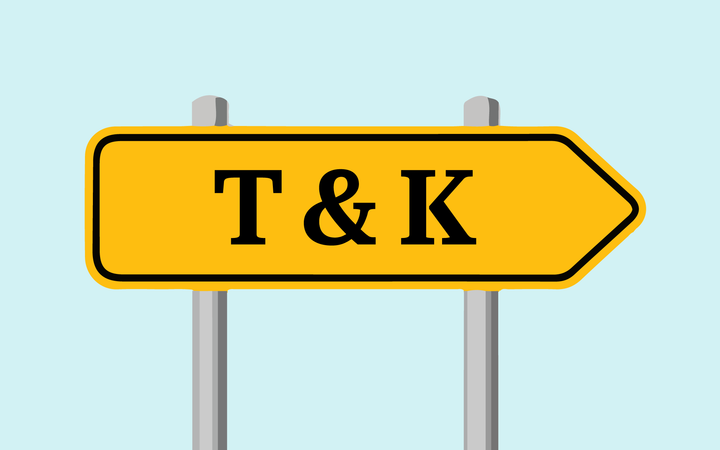 Keltainen nuolenkärkinen kyltti, jossa lukee "T & K".