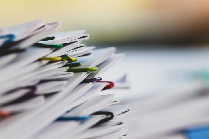 Paperipino, joka kiinnitetty yhteen monella värillisellä klemmarilla.