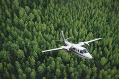 Maanmittauslaitoksen ilmakuvauslentokone metsän yllä