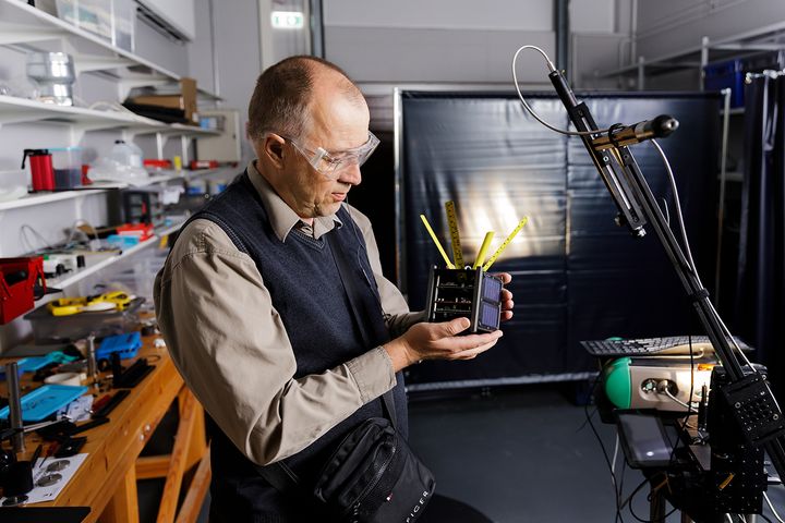 Tutkimuksen avulla avaruusromun kappaleita pystytään tarkkailemaan, jotta ne eivät aiheuta törmäysriskejä satelliitteihin. Tähän tavoitteeseen tutkijat tuottavat aineistoja satelliittien ja avaruusromun kappaleiden ominaisuuksista. Kuvassa tutkimusryhmäpäällikkö Jouni Peltoniemi valmistelee KitSat-mallisatelliittia mittauksia varten.