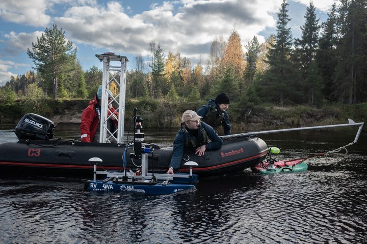 Joella vene, jossa on kolme ihmistä ja erilaisia tutkimuslaitteita