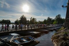 Kuva: Ihmisiä kävelemässä sillalla Olavinlinnan edustalla aurinkoisena päivänä.