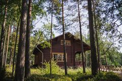 Punainen puurakennus metsäisellä alueella, puiden keskellä.
