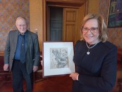 Teos ylijohtajan kädessä, jossa on kuvattu suomalaisen sotilaan ilmeikkäät kasvot. Teoksessa on signeeraus AHL.