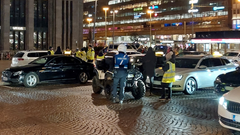 Valvontaviranomaisia ja takseja Helsingin rautatieaseman edustalla illalla.