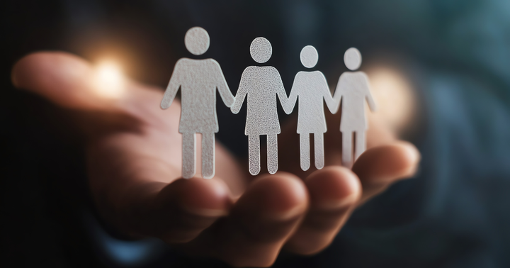 En hand håller fyra figurer som representerar ett gemenskap.