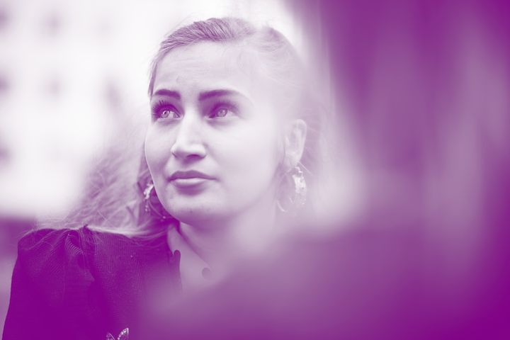 Romaninainen, joka katsoo yläviistoon perinnepuvussaan.