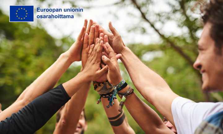 Joukko nuoria kurottavat käsillä toisiaan kohti.