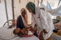 Hoitaja tutkii aliravitsemusta sairastavaa lasta sairaalassa.