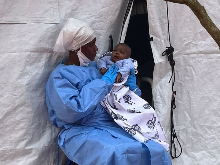 Asanté-vauvan vanhemmat kuolivat ebolatautiin. Taudista itse parantunut Francine Virungi on osa ”suojelusenkelit” -ryhmää. He ovat ebolasta itse parantuneita hoitajia, jotka ovat tulleet väliaikaisesti immuuneiksi ja hoitavat ebolaa sairastavia lapsia. Kuva on otettu elokuussa 2026. Virungi on sittemmin adoptoinut Asantén.