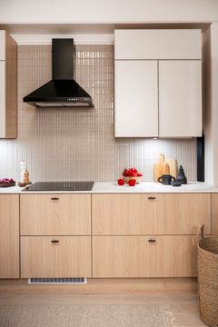 Keittiö, jossa Venetsian tammi -sävyiset alakaapit ja vaaleat kitti-sävyiset yläkaapit.