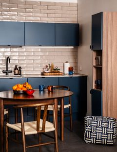 Sininen Viona-keittiö, jossa ala- ja yläkaapit, oikealla pitkä avohylly ja etualalla pyöreä ruskea ruokapöytä ja tuolit.