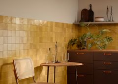 Okran sävyinen laatta keittiön välitilassa ja seinässä.