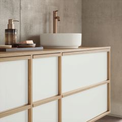 Baroom-allaskaluste, jonka kalusteovissa on vaaleasta puusta kehyksen. Muuten ovi on valkoinen.