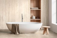 Ragnon vaalea Realstone Travertino -laatta kylpyhuoneen seinässä ja lattiassa. Keskellä kuvaa ovaali kylpyamme.