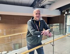 Henkilö nojaa lasikaiteeseen.