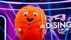 Oranssi, karvainen maskottihahmo on Masked Singer -ohjelman lavasteissa