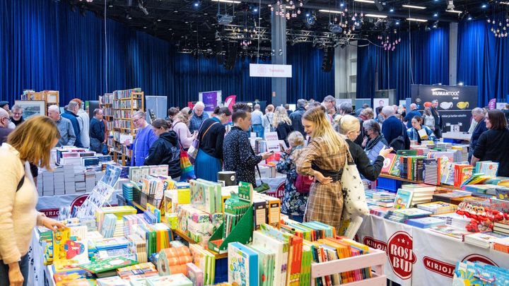 Alt-teksti: Ihmisiä tutkimassa kirjoja Tampereen Kirjafestareiden kirjakaupassa.