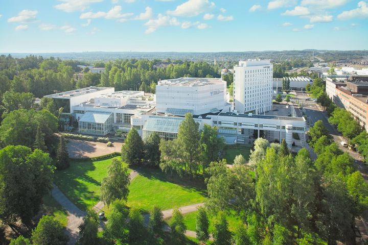 Ilmakuva Tampere-talosta kesäisessä maisemassa, ympärillä vehreää puistoaluetta.