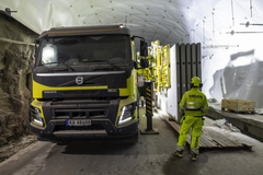 Työntekijä ja kuorma-auto tunnelin rakennustyömaalla.