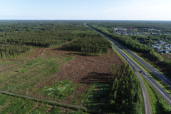 Ilmakuva alueesta Oulun keskustan pohjoispuolella, jossa on metsää, avohakkuualue ja valtatieltä haarautuva tie.