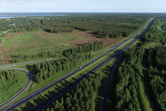 Ilmakuva rakenteilla olevasta tiehankkeesta vehreässä ja metsäisessä maastossa Oulussa.