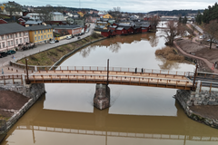 Vanhan Porvoon uudistettu silta ylittää joen, ja sen ympärillä näkyy historiallisia rakennuksia.