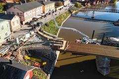 Ilmakuva Vanhan Porvoon sillasta, jonka reunapalkkia ja suojabetonia valetaan Porvoonjoella kelluvalta työlautalta.