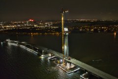 Ilmakuva Kruunuvuorensillasta kesällä 2023, työmaa valaistuna yöllä.