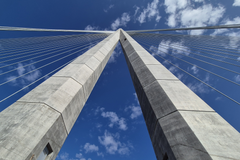 Kruunuvuorensillan pyloni, joka kohoaa 135 metriin sinistä taivasta vasten.