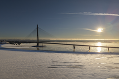 Luminen maisema Kruunuvuorensillasta Helsingin edustalla, aurinko paistaa matalalta talvisella taivaalla.