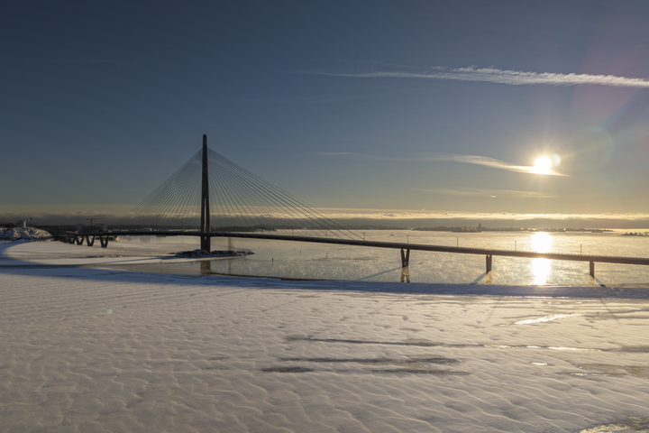Luminen maisema Kruunuvuorensillasta Helsingin edustalla, aurinko paistaa matalalta talvisella taivaalla.