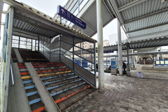 Kuva Kannelmäen juna-asemalta, jossa näkyy kirkkain värein maalatut portaat ja vieressä luiska.