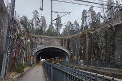 Kuva Malminkartanon rautatieasemasta, jossa näkyy kallioleikkauksia ja asematunneli. Sateinen sää ja märät kalliot.