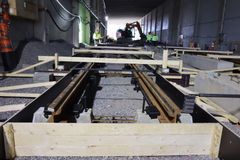 Valokuva näyttää rakennustyömaan, jossa etualalla ovat irtokiinnikkeet asennettuina betonialustalle. Taustalla kirkkaita valoja ja työkoneita.