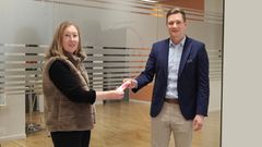 Kuvassa mies ojentaa lahjoituskorttia naiselle