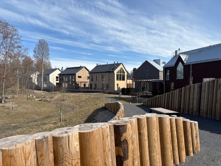 Hartaanselänrannan Asuntomessualueella moderneja taloja ja puurakennuksia avoimella alueella, Hietasaaressa Oulun Oulujoen jokisuistossa.