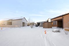 Rakenteilla olevia pientaloja talvisessa maisemassa ja auringonpaistetta.