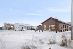 Rakenteilla olevia pientaloja lumisessa maisemassa.