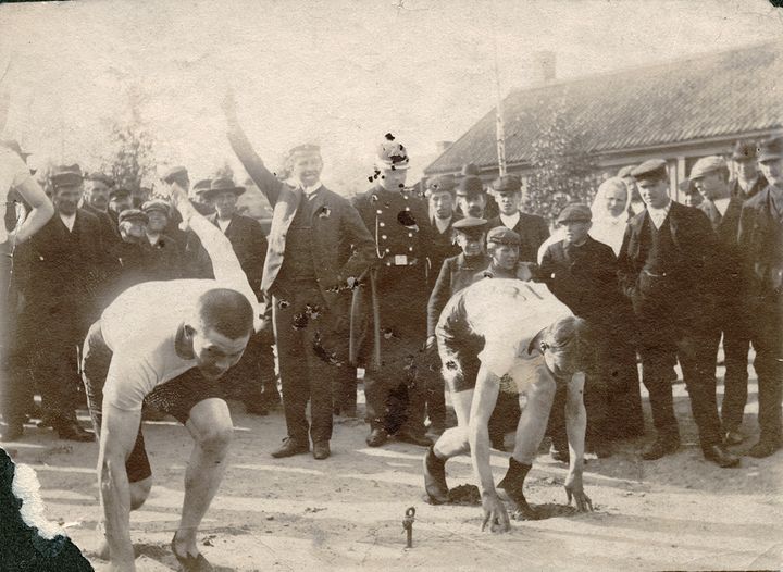 Idrottens Wänner arrangerade en friidrottstävling i Gamlakarleby 17-18.8.1907. Enligt tidningen var det en lyckad tävling. En stor skara deltagarna och tittare fanns på plats, också vädret var toppen. Museet har en bildserie från tävlingen. Enligt tidningen tävlade man i bl.a. kulstötning, längdhopp, spjutkast, löpning och säcklöpning. Detta foto är antagligen från samma tävling, men vi känner inte till personerna på det. Har du info om detta? Kontakta museet: museo.tietopalvelu(at)kokkola.fi.